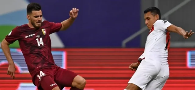 Alex Valera y Luis del Pino disputan el balón en el partido entre Venezuela y Perú / Foto: AFP