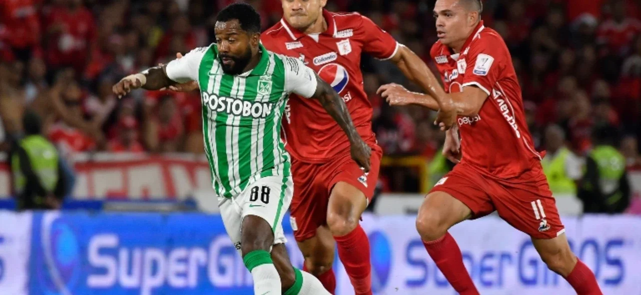 Carlos Sierra disputa el balón con Dorlan Pabón del Nacional. / VizzorImage / Gabriel Aponte