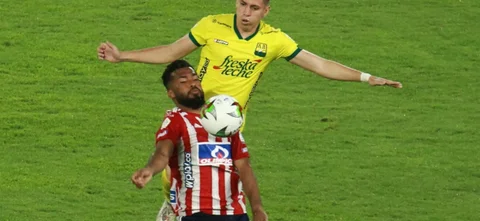 Luis González de Junior disputa el balón con Johan Caballero de Bucaramanga | VizzorImage / Jesús Rico