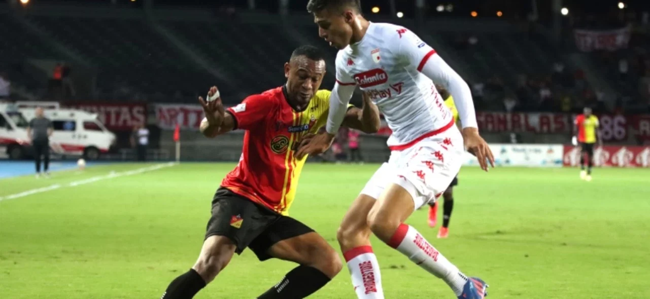 Ángelo Rodríguez disputa un balón contra David Ramírez - VizzorImage / Pablo Bohórquez