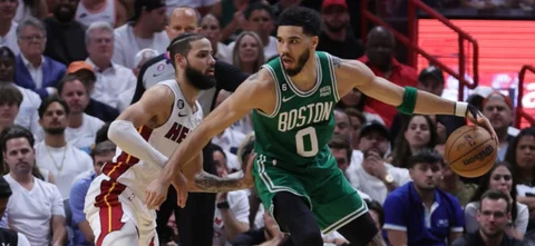 Caleb Martín (blanco) busca evitar un ataque de Jayson Tatum (verde) - AFP