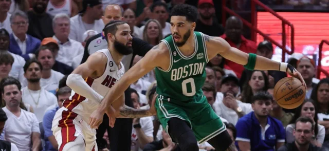 Caleb Martín (blanco) busca evitar un ataque de Jayson Tatum (verde) - AFP