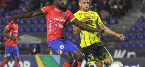 Cristián Tovar (rojo) y Andrés Rodríguez corren tras un balón - VizzorImage / Leonardo Castro