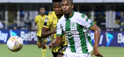 Danovis Banguero (verdiblanco) y Edwin Torres (aurinegro) persiguen el balón - VizzorImage / Jose David Martinez