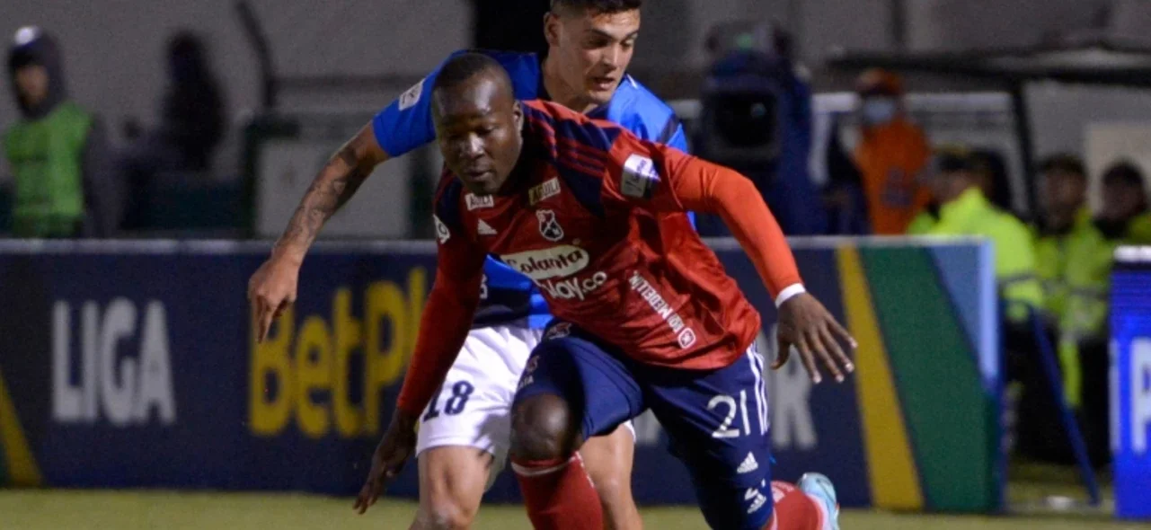 Emerson Batalla (rojo) protege un balón de Agustín Aleo - VizzorImage / Macgiver Baron