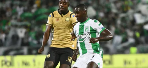 Marco Pérez (dorado) persigue la pelota que tiene en control Cristián Zapata - VizzorImage / Luis Benavides