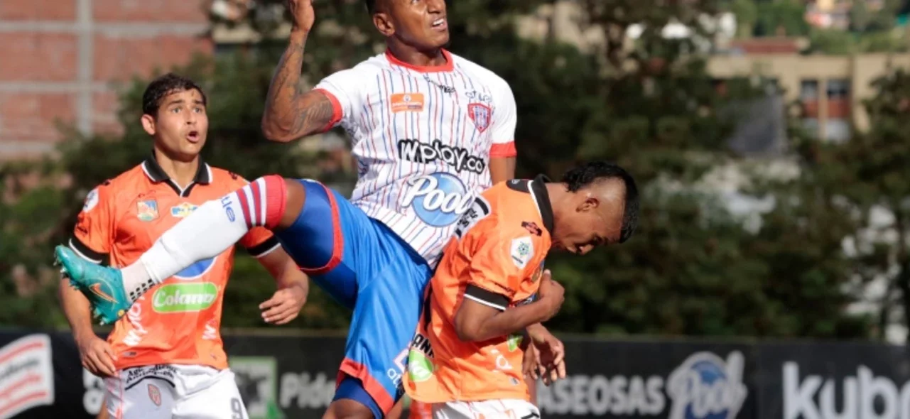 Juan Camilo Ángulo (blanco) y Rubio España (anaranjado) en disputa de un balón aéreo - VizzorImage / Donaldo Zuluaga