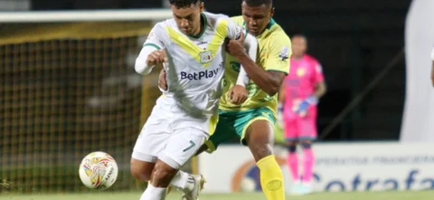 Ariel Roa (blanco) y Yeison Fuentes (amarillo) disputan un balón - VizzorImage / Paulina Betancur