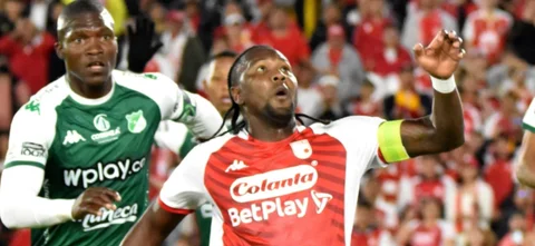 Germán Mera (verde) y Hugo Rodallega (rojo) disputan un balón - VizzorImage / Felipe Caicedo