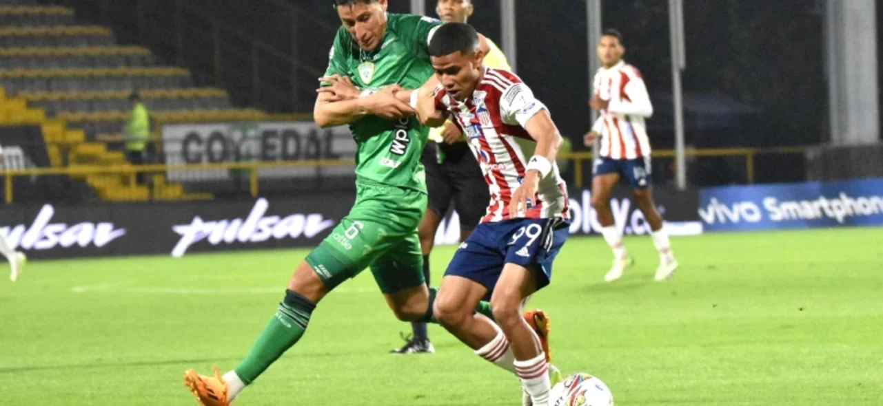 José Enamorado (blanquirojo) defiende un balón de Pablo Lima (verde) - VizzorImage / Felipe Caicedo