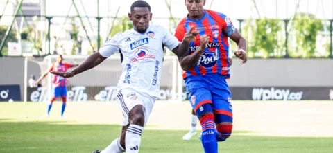 Pablo Rojas disputa un balón contra Juan Camilo Ángulo - VizzorImage / Jean Carlos Araujo