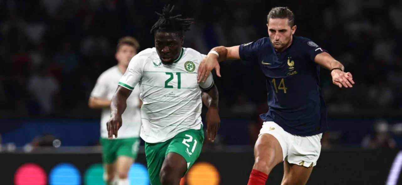 Festy Ebosele disputa un balón con Adrien Rabiot - AFP