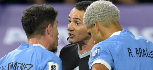 Wilmar Roldán dialoga con los dos centrales de Uruguay, Giménez y Araújo - AFP
