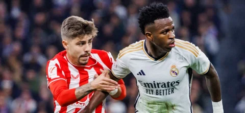 Álex Poso disputa un balón contra Vinicius Jr. - AFP