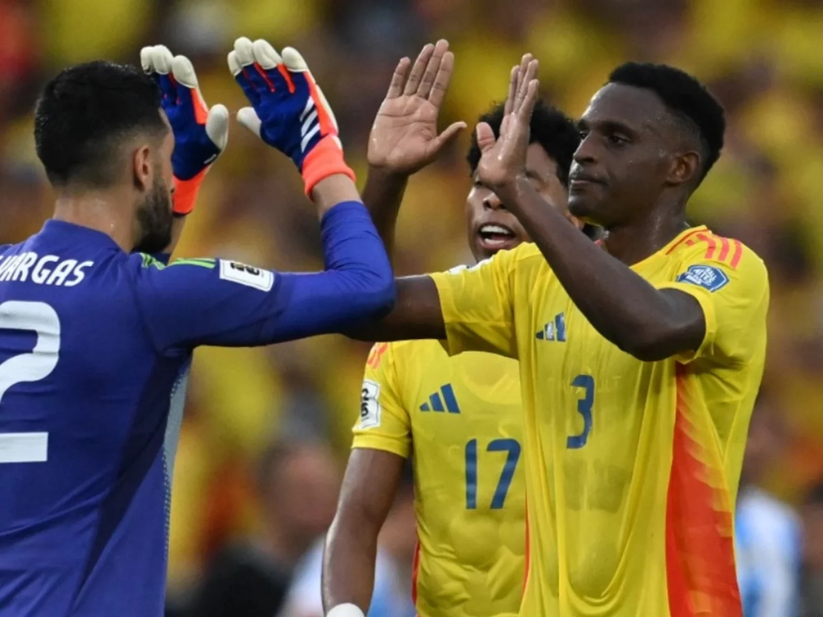 Camilo Vargas celebra con los defensores Jhon Lucumí y Johan Mojica - AFP